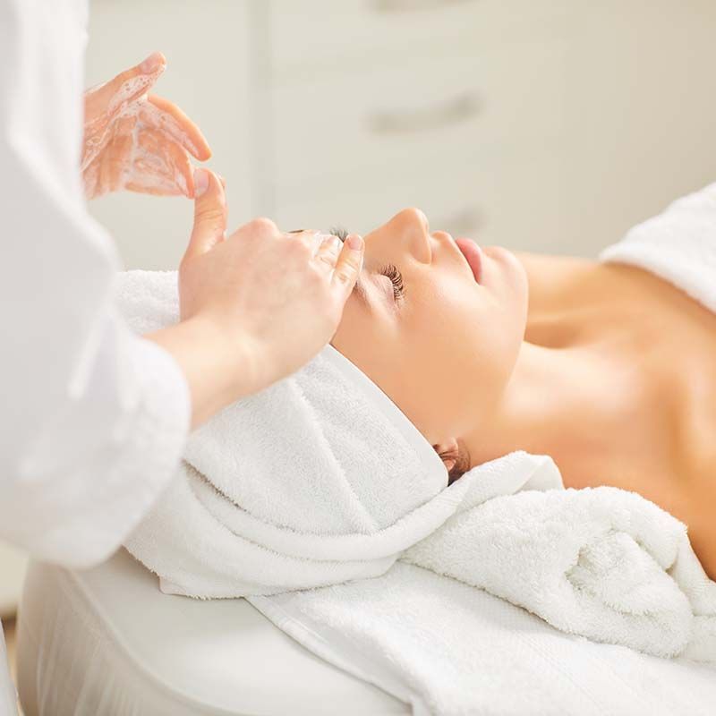 A woman is getting a facial treatment at a spa.