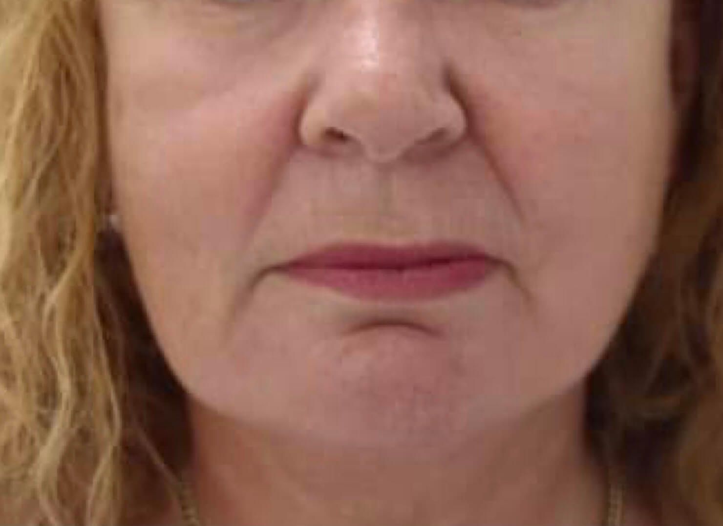 A close up of a woman 's face with a serious look on her face.