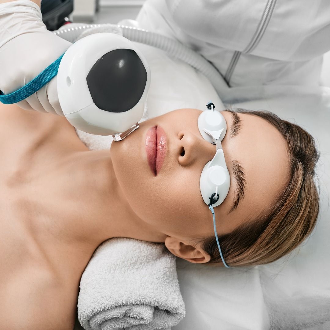 A woman is getting a laser treatment on her face.