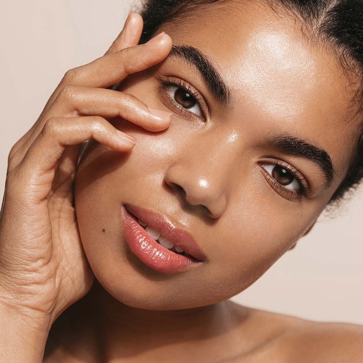 A close up of a woman 's face with her hand on her face
