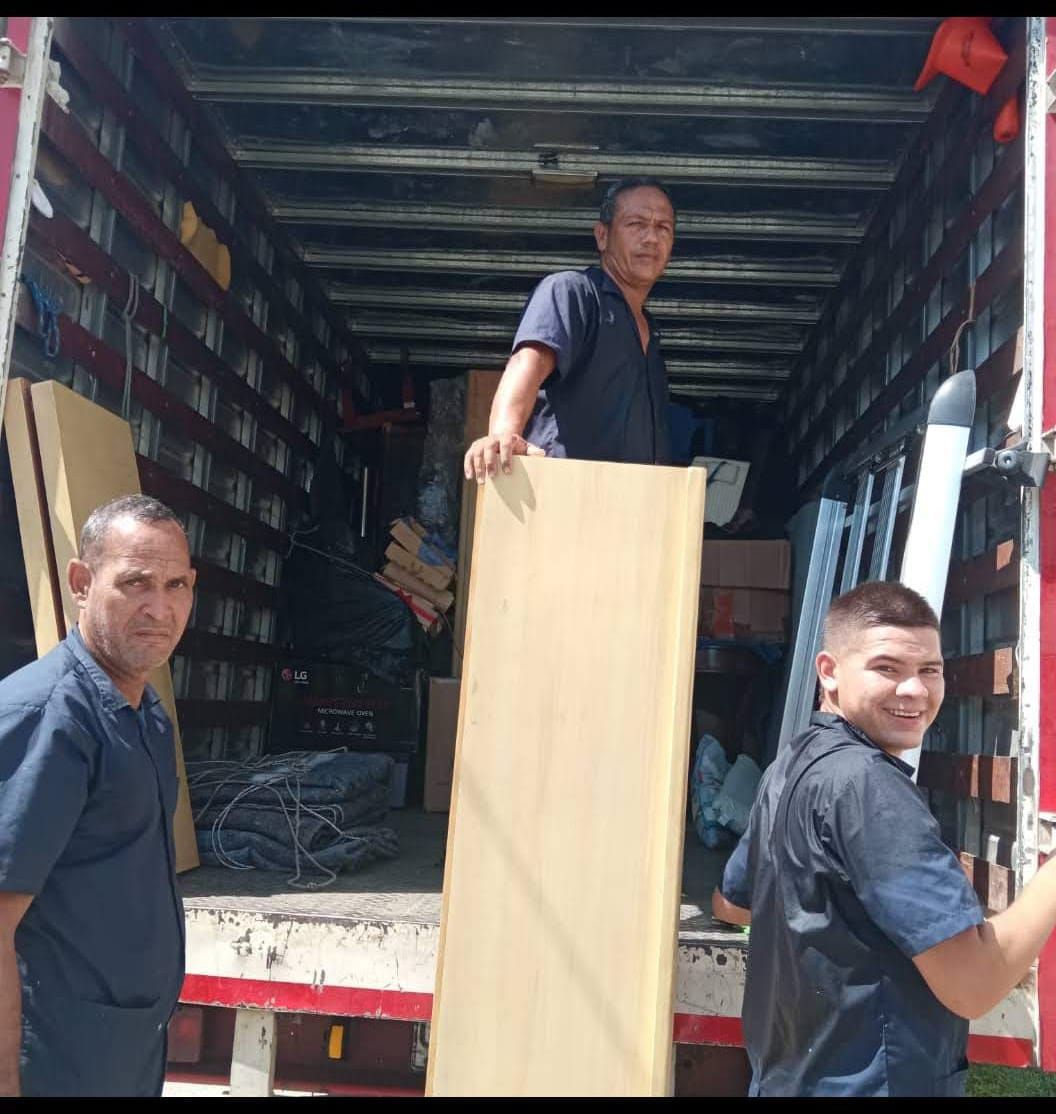 Un hombre sostiene un trozo de madera en la parte trasera de un camión.