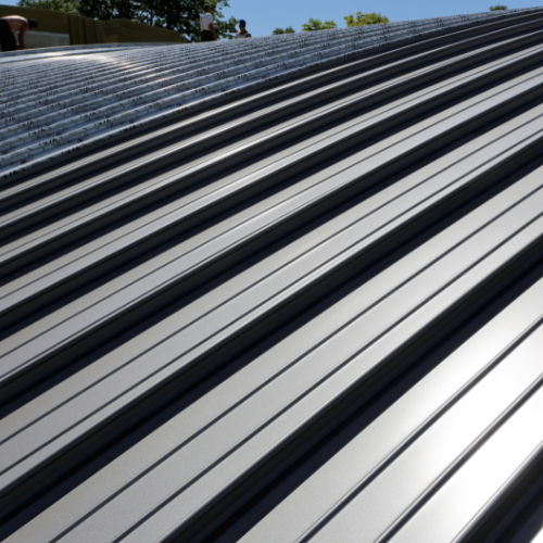 A close up of a metal roof with a blue sky in the background.