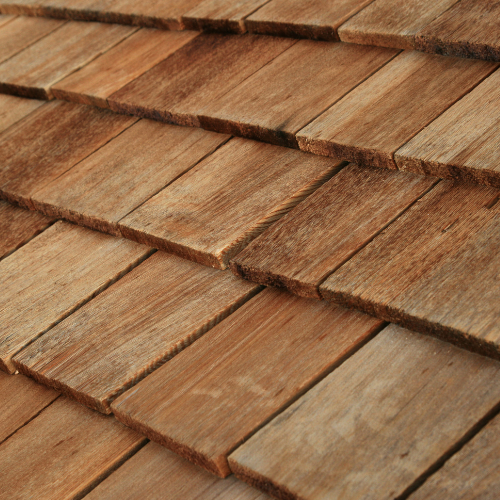 Close-up of overlapping brown wooden roof shingles.