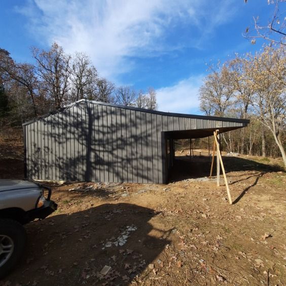 A car is parked in front of a building in the woods