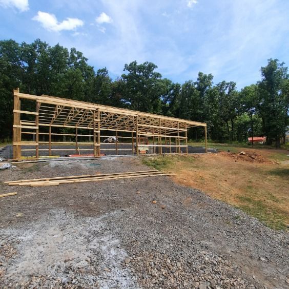 A large wooden structure is being built in the middle of a dirt field