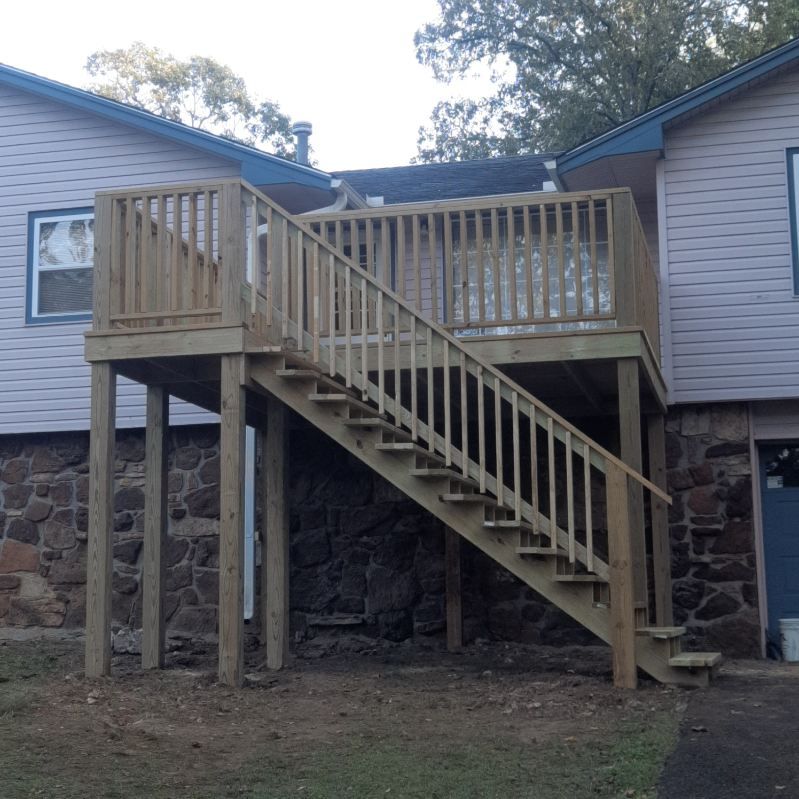 A house with a wooden deck and stairs leading up to it