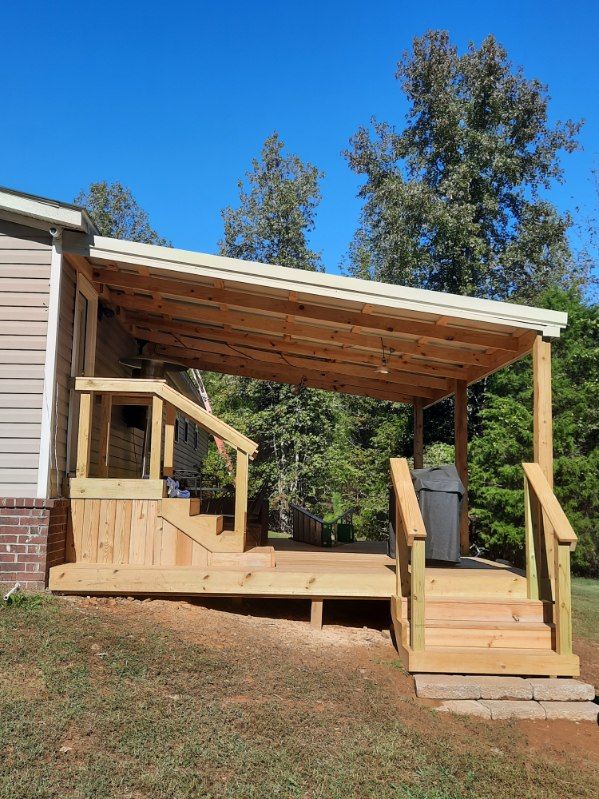 A wooden deck with stairs and a covered porch next to a house.