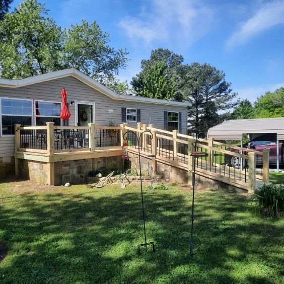 A mobile home with a wooden deck and a ramp