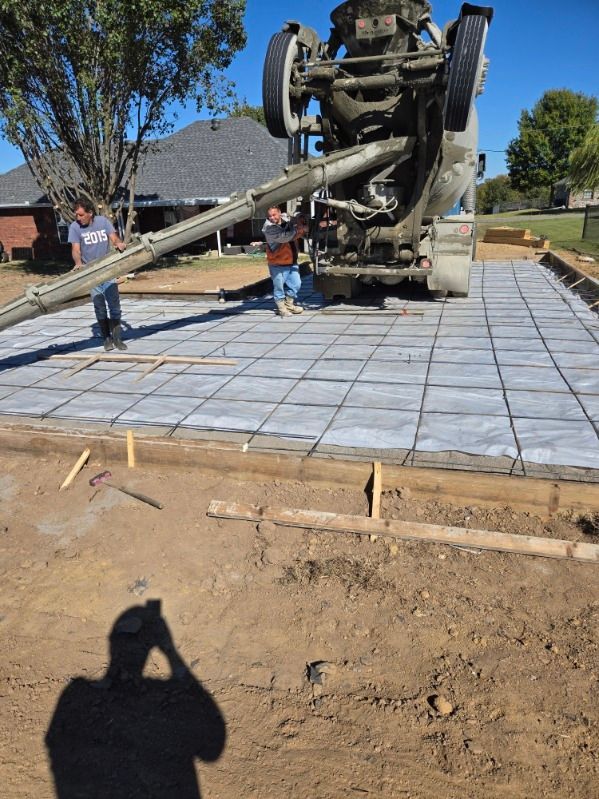 A Man is Taking a Picture of a Concrete Truck Pouring Concrete