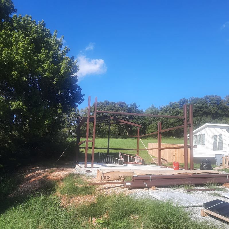 A house is being built in the middle of a grassy field