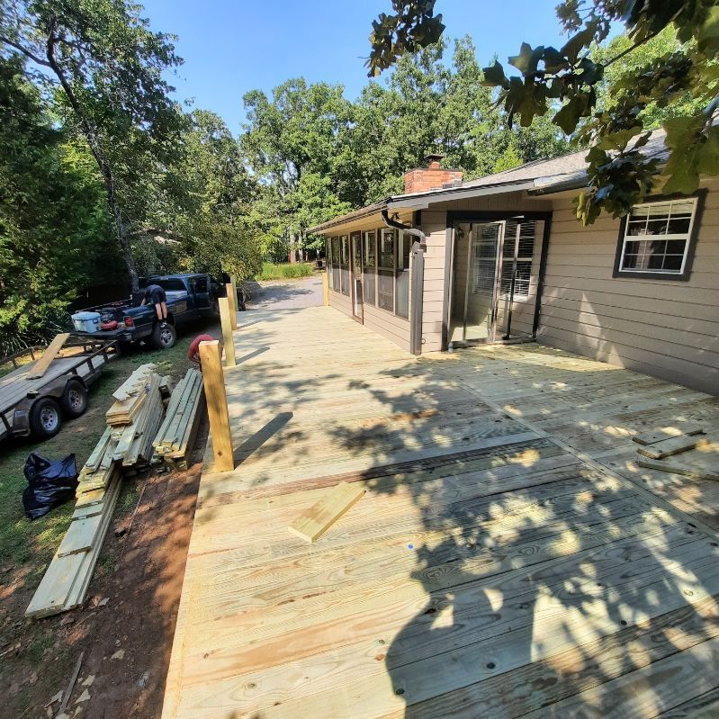 A wooden deck is being built in front of a house