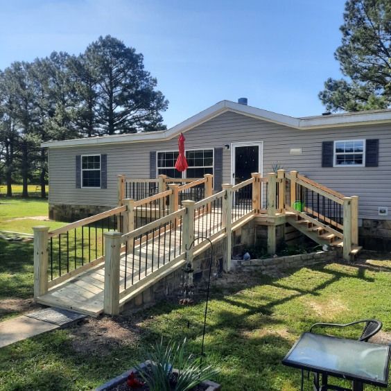 A mobile home with a wooden deck and stairs