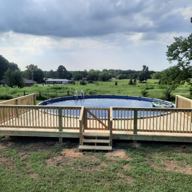 A large swimming pool with a wooden deck around it