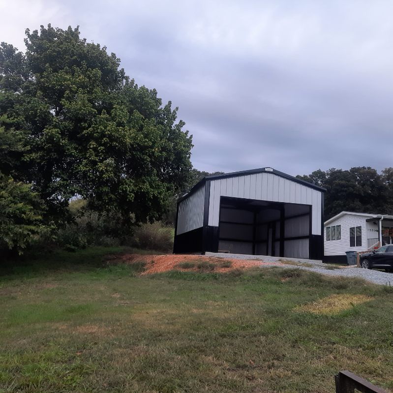 A black and white building with a sliding garage door
