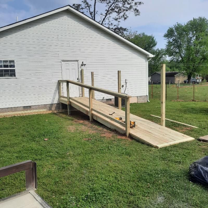 A wooden ramp is being built in front of a white house.