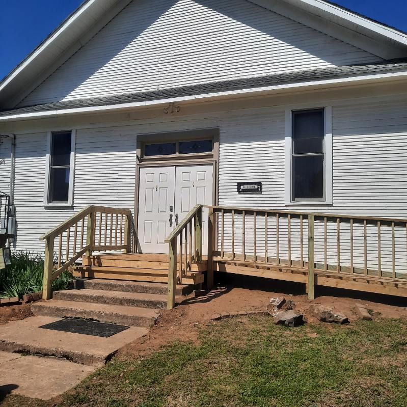 A white house with a wooden ramp and stairs