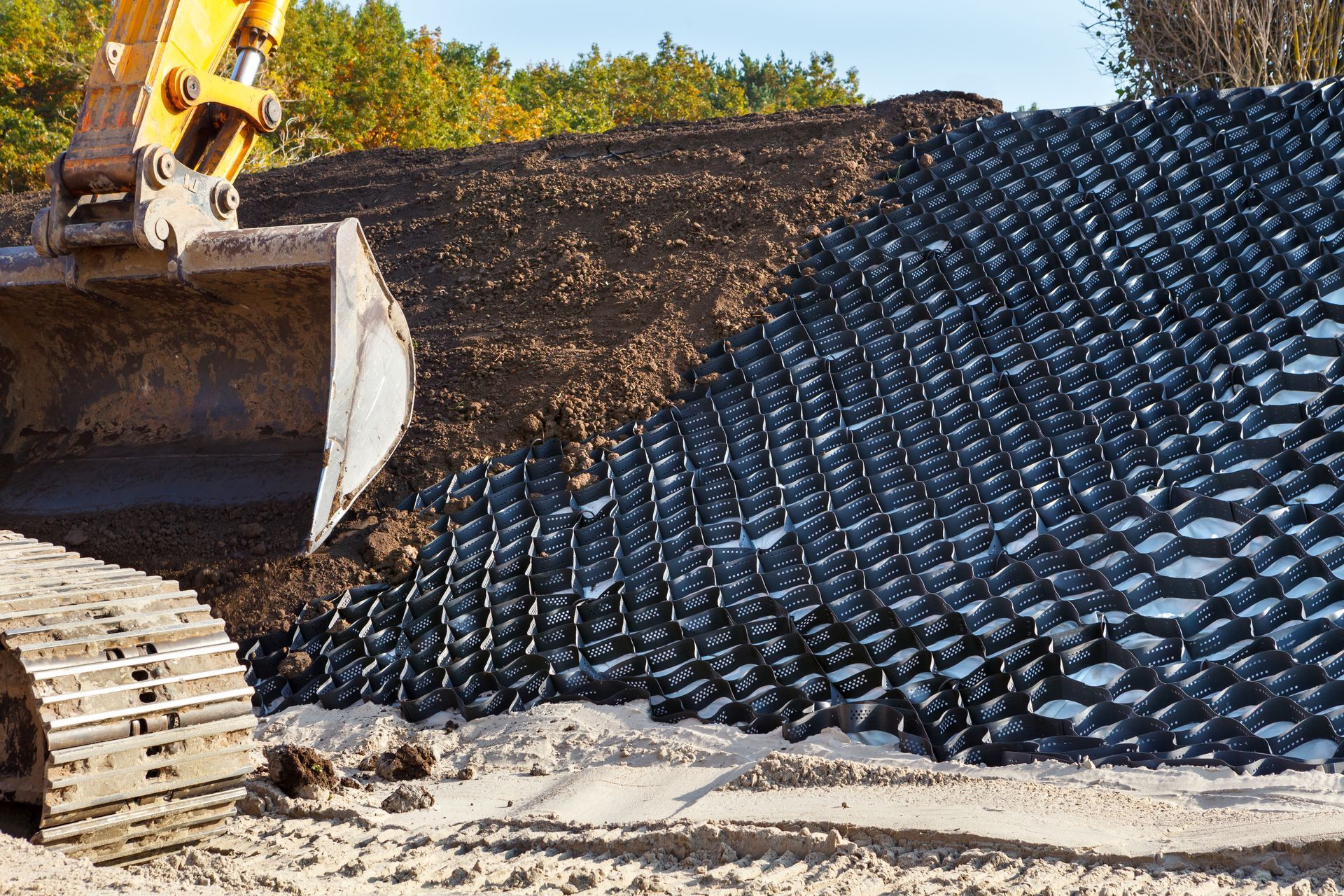 Geotechnical slope stabilization using polymer geogrid reinforcement in sandy soil conditions.
