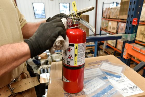 # Alarm Fire & Safety wiping down an inspected fire extinguisher