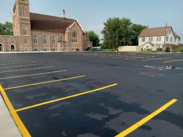 An empty parking lot with a church in the background