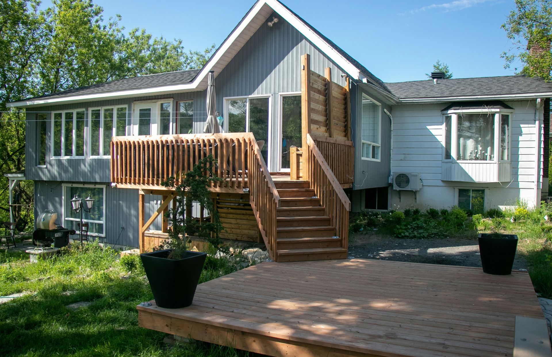 A white house with a wooden deck and stairs