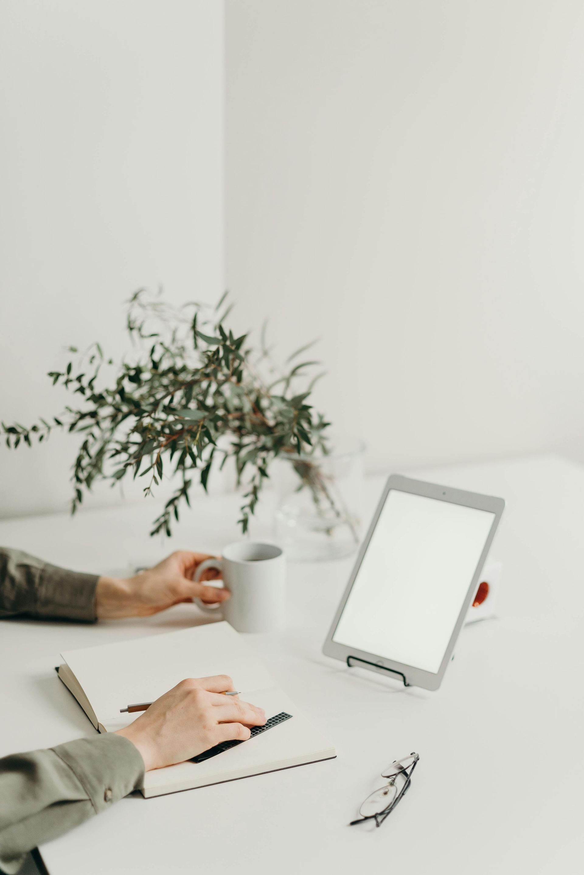 An ipad on a desk with a plant