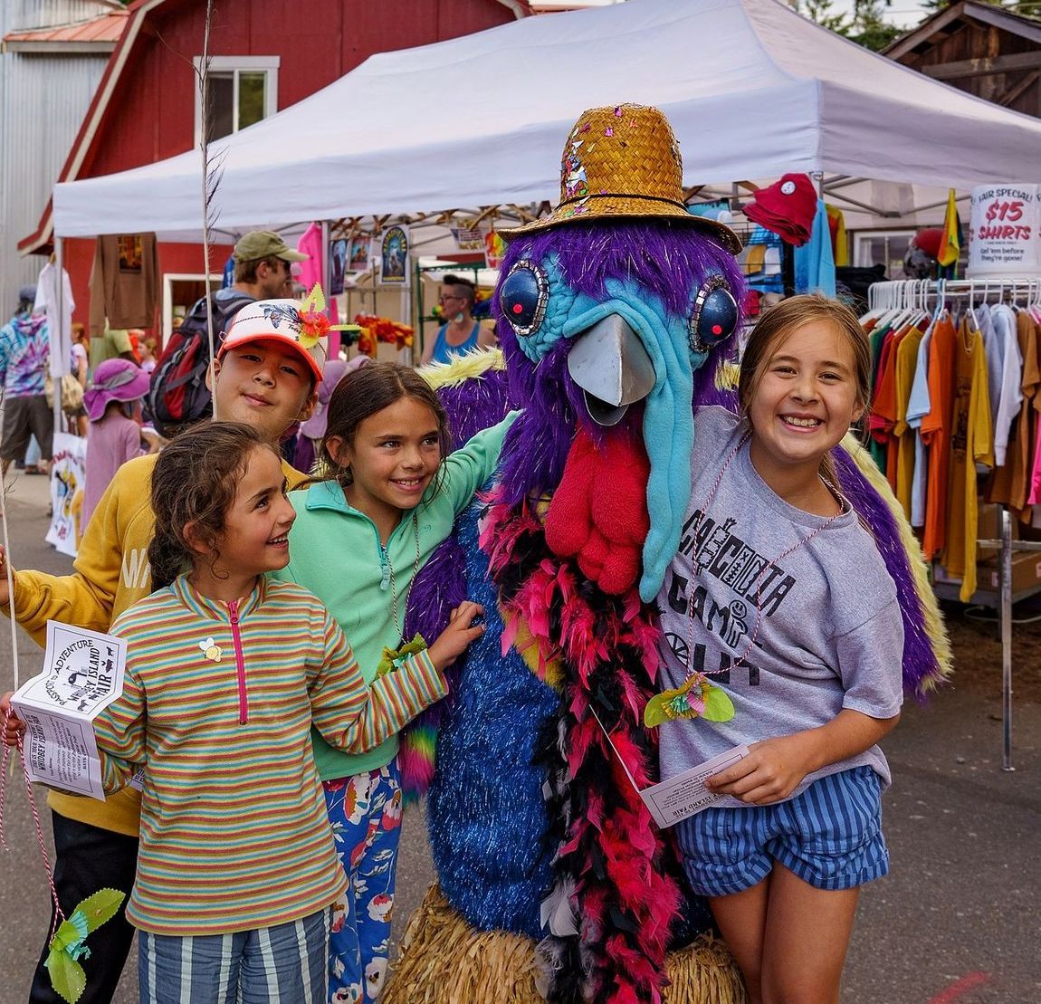 A group of children are posing for a picture with a turkey mascot