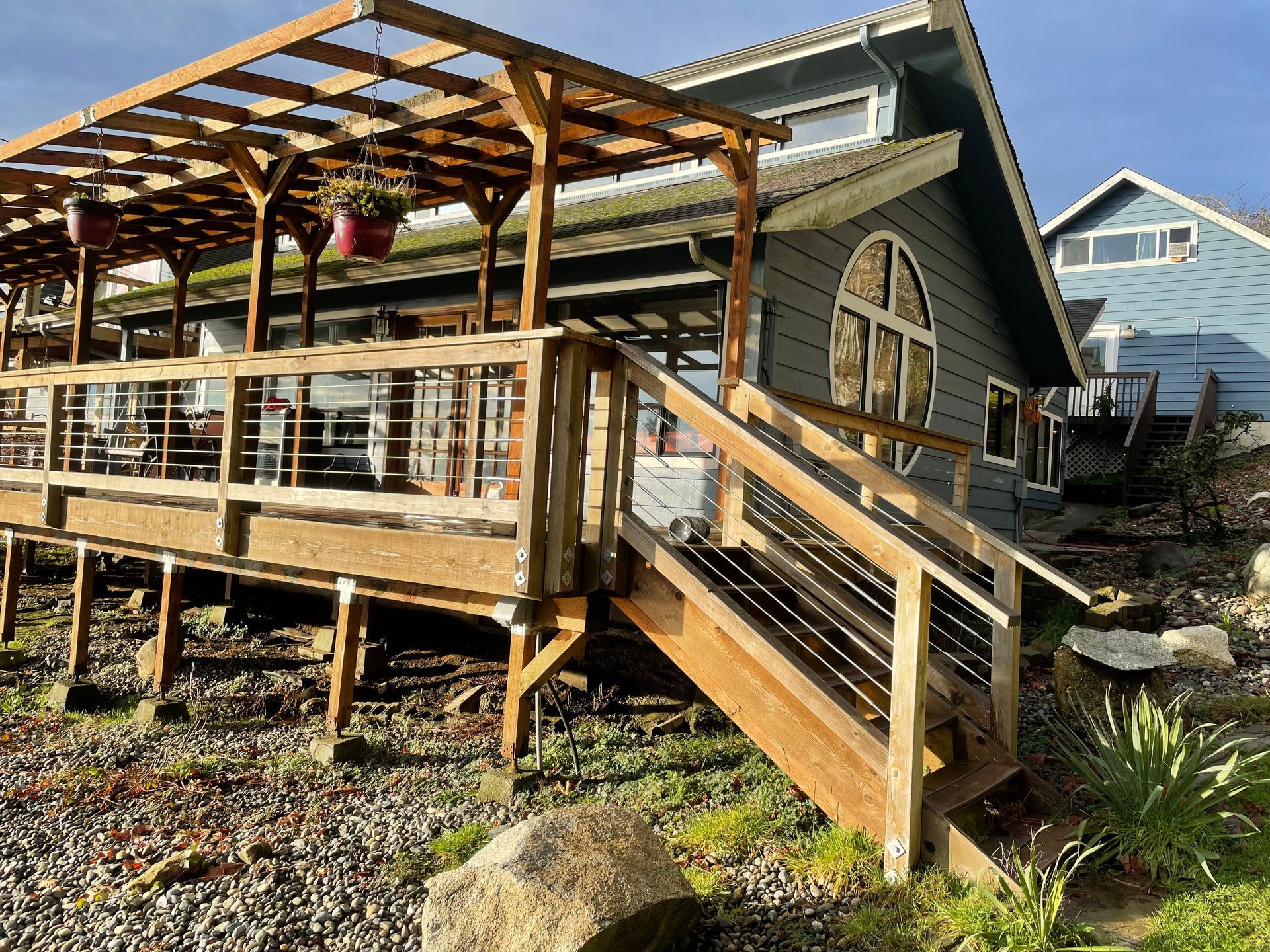 A house with a large wooden deck and stairs leading up to it.