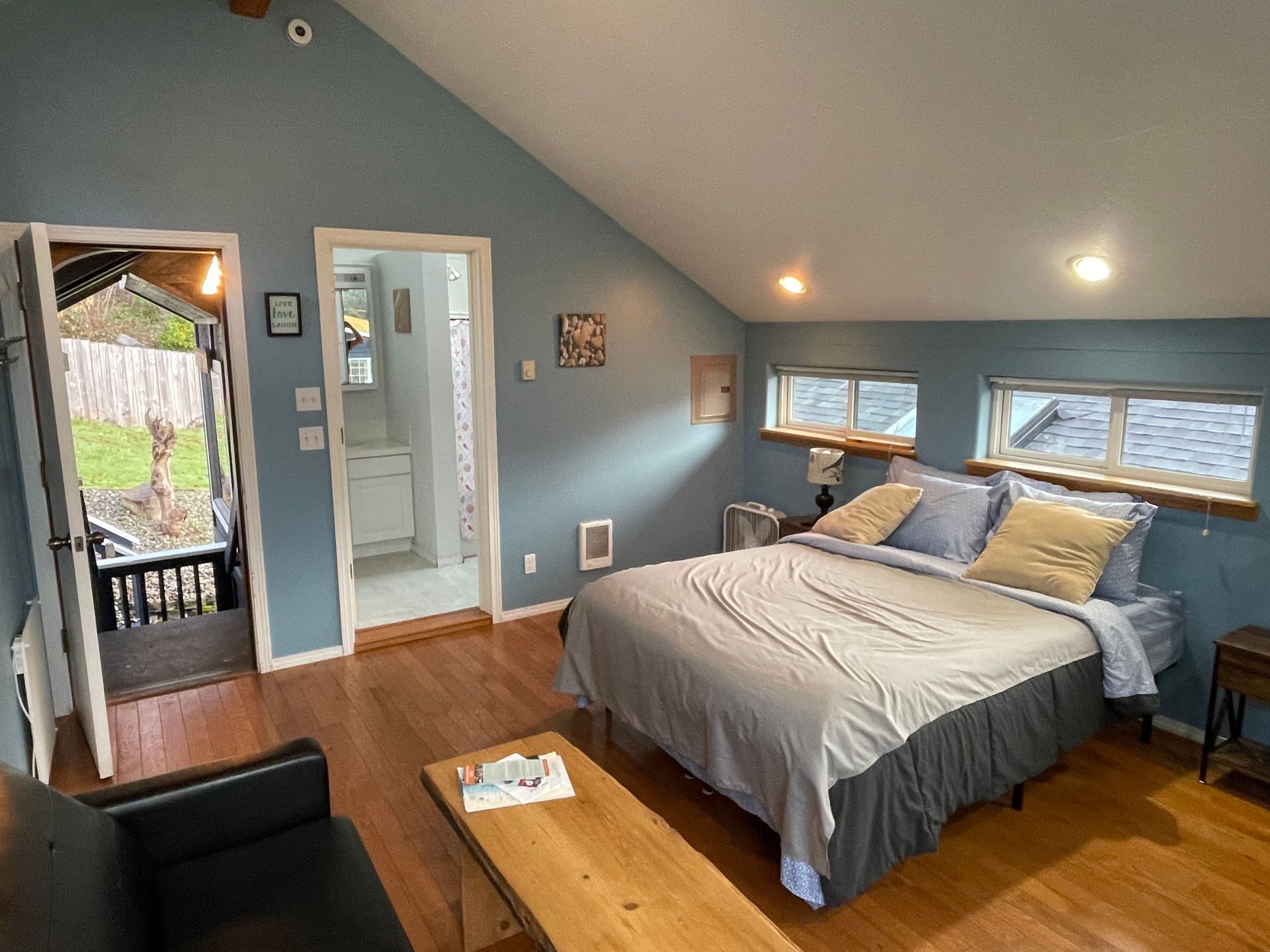 A living room with a blue couch and a lot of windows