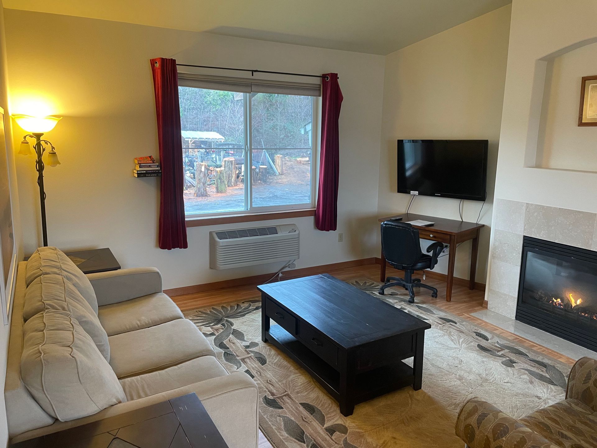 A living room with a couch , coffee table , fireplace and television.