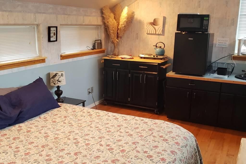 A bedroom with a bed , cabinets and a microwave