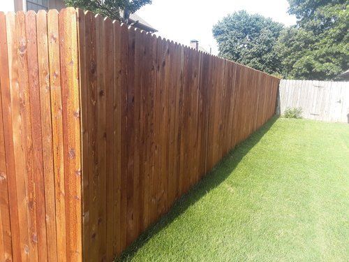 A wooden fence is sitting on top of a lush green lawn.