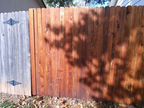 A wooden fence with a shadow of a tree on it.