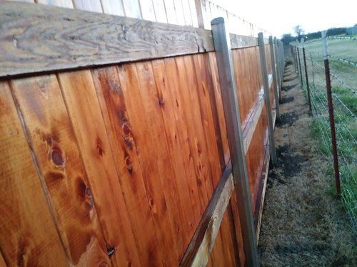 A wooden fence is sitting in the middle of a field.