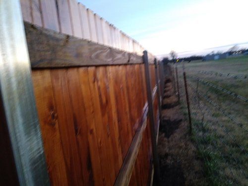 A close up of a wooden fence in a field.