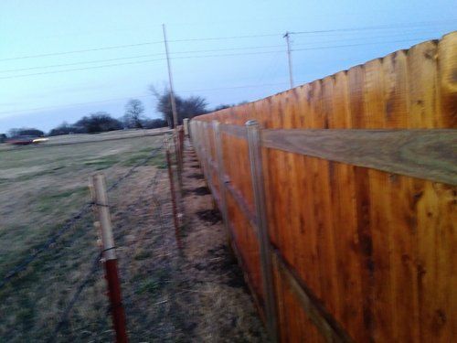 A wooden fence is sitting in the middle of a field.