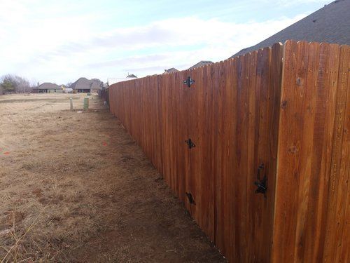 A wooden fence is sitting in the middle of a field.