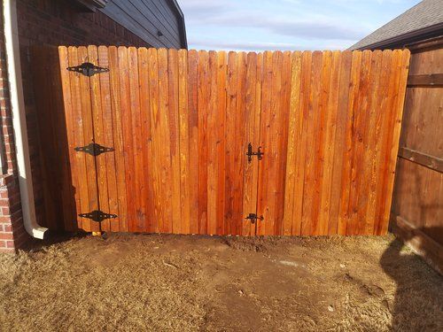A wooden fence is sitting in front of a brick building.