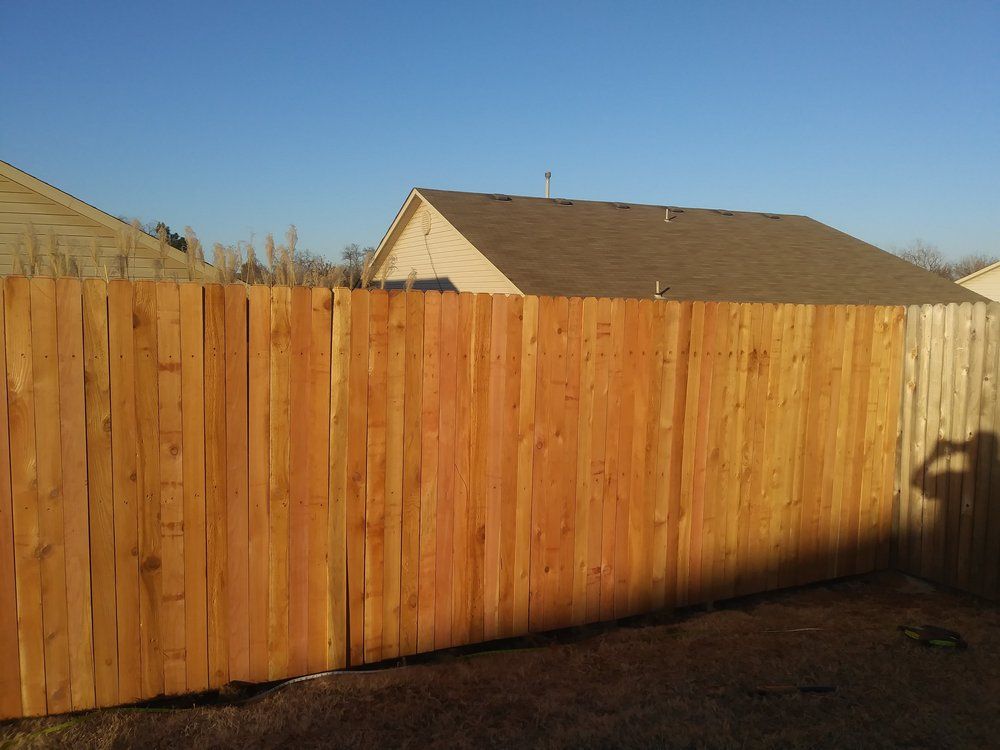 A wooden fence with a house in the background