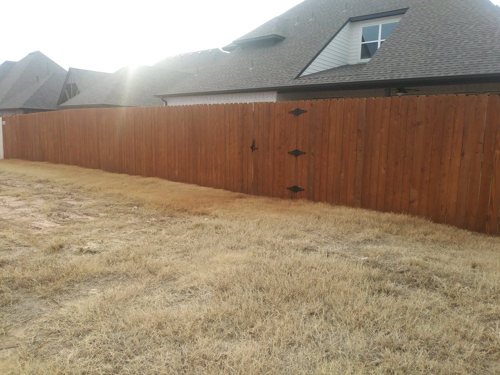 A wooden fence with a gate in the backyard of a house.