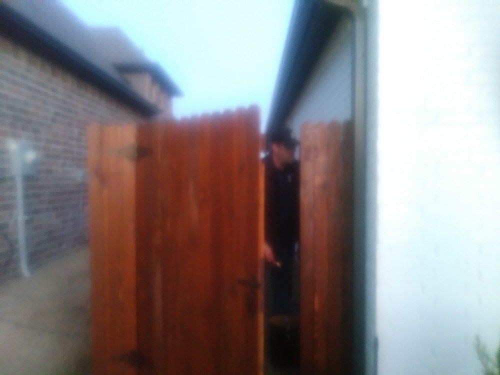 A blurry picture of a man standing behind a wooden fence.