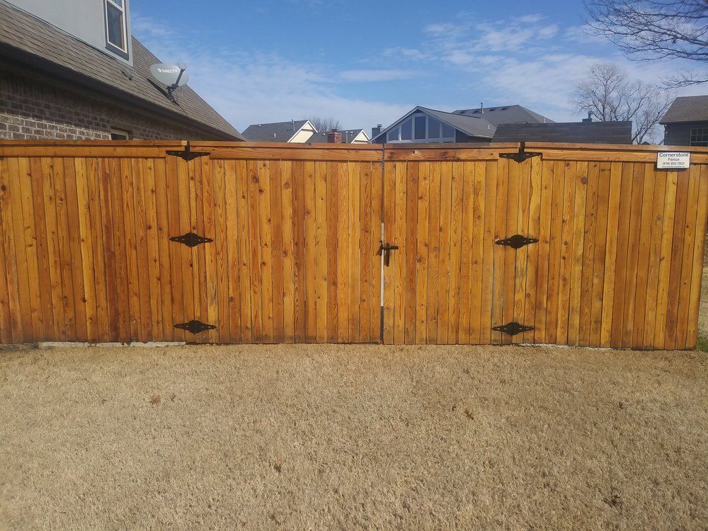 A wooden fence with a gate in front of a house.