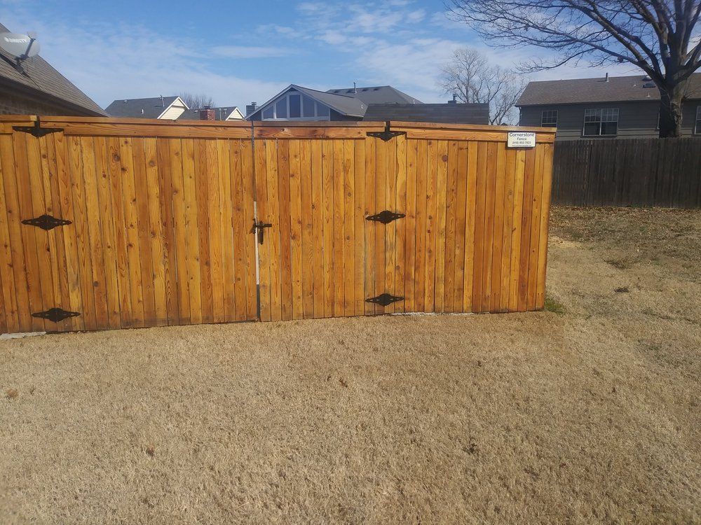 A wooden fence with a gate in the backyard of a house.