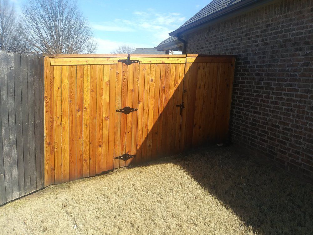 A wooden fence is next to a brick building