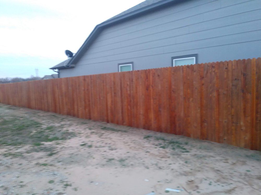 A wooden fence along the side of a house