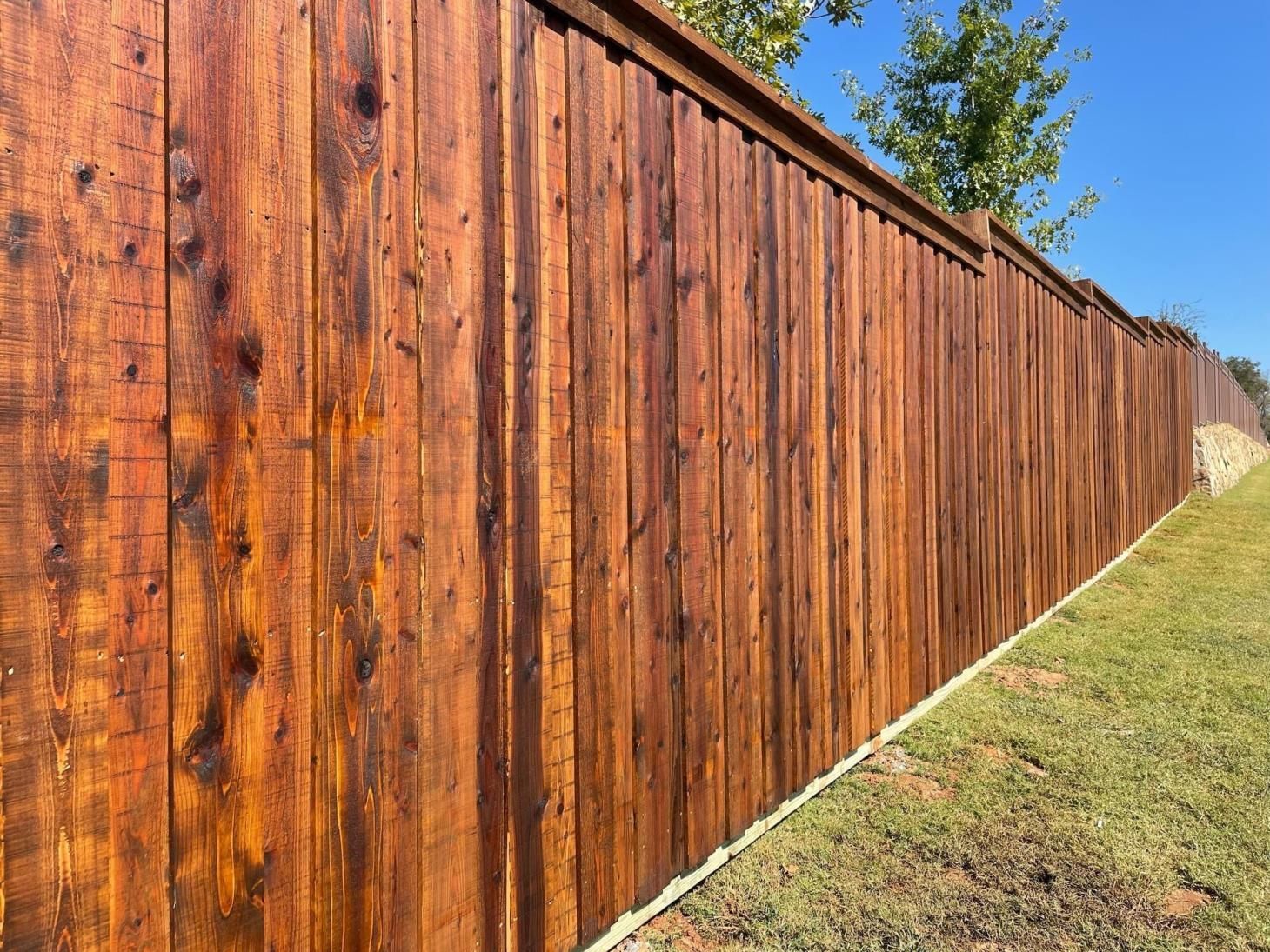 A wooden fence is sitting on top of a lush green field.