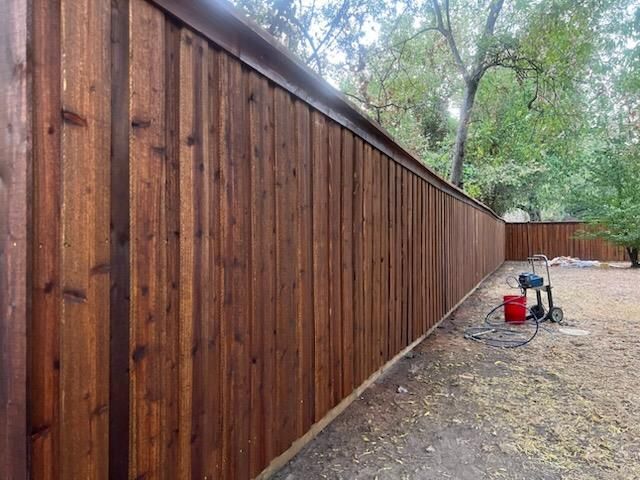 A wooden fence is being built in a backyard.