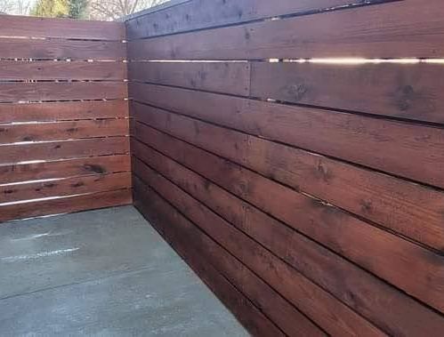 A wooden fence is sitting on top of a concrete floor.