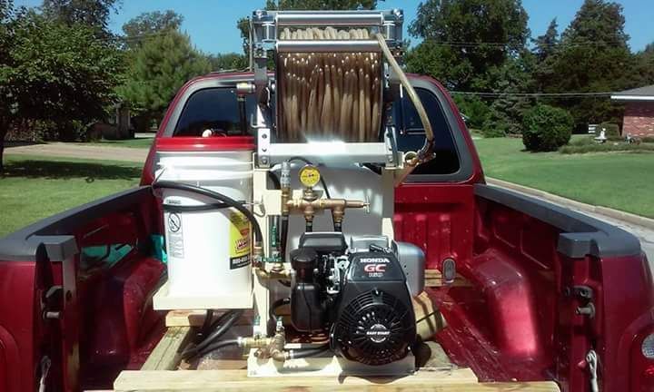 A red truck with a machine in the back of it