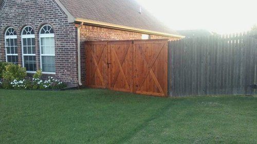 A brick house with a wooden fence in front of it.
