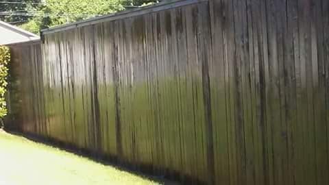 A wooden fence is sitting on top of a lush green lawn.